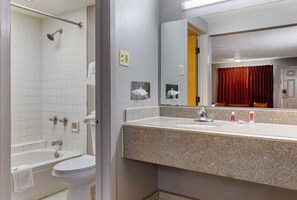 A bathroom with a bathtub, toilet, sink, and a mirror. - Econo Lodge Wichita Falls Downtown (Wichita Falls)