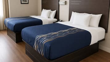 A hotel room with two beds, each with a dark headboard and white bedding.