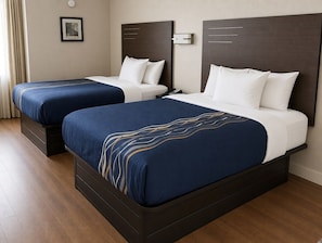 A hotel room with two beds, each with a dark headboard and white bedding. - Lakeside Inn (Guntersville)