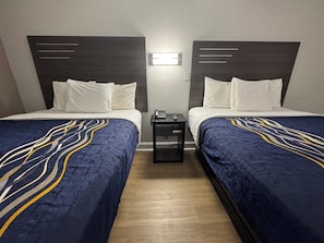 Habitación estándar, 2 camas Queen size | Tabla de planchar con plancha, wifi gratis, ropa de cama y despertador