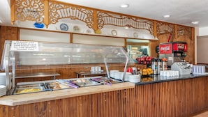 A buffet area with a wooden counter, a glass display case, and a Coca-Cola machine.