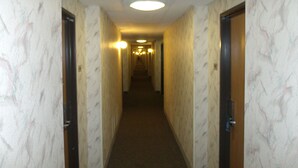 A narrow hallway with marble-patterned walls and doors on both sides. - Relax Inn (Davenport)