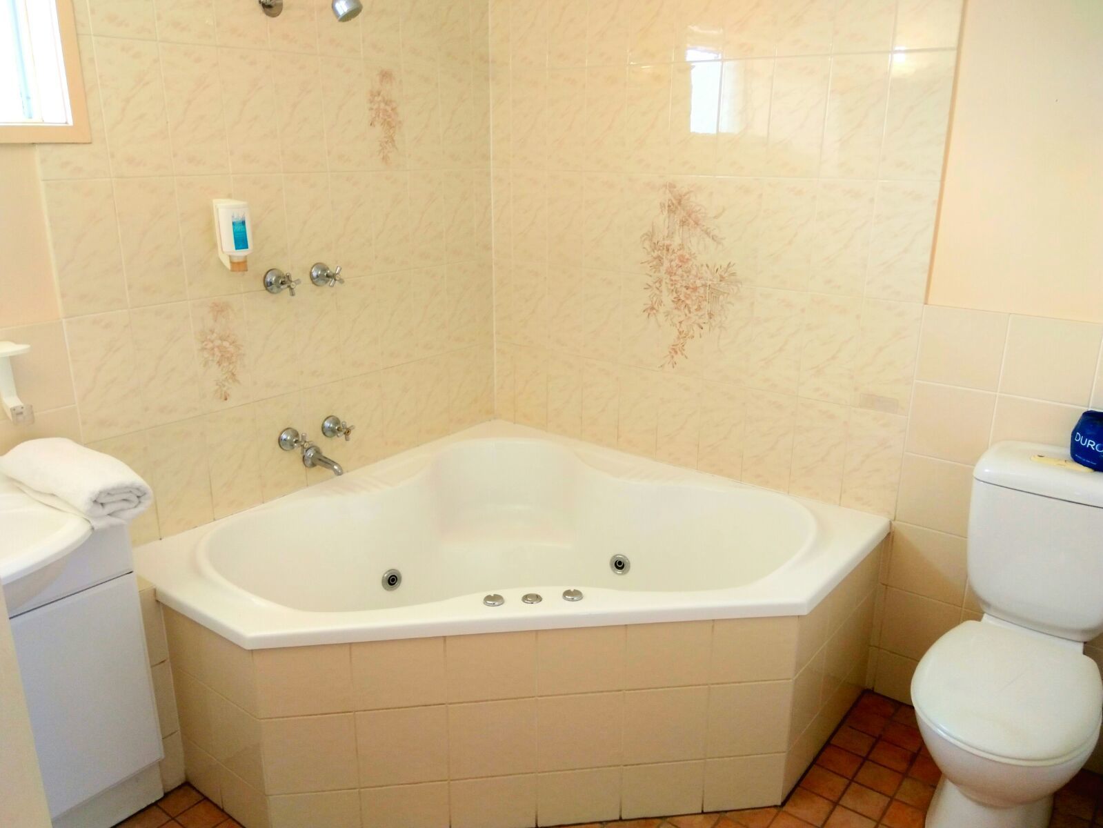 Une salle de bain avec une grande baignoire, des toilettes et un lavabo.