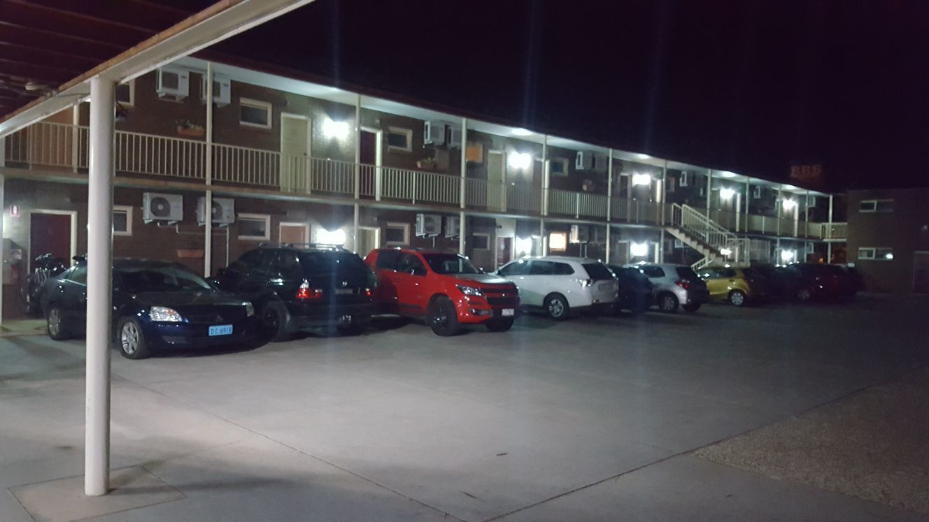 Eine mehrstöckige Parkgarage mit mehreren Autos, die unter einem Überdachung parken.