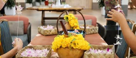 A table with woven baskets containing flowers and a central pot with yellow flowers.
