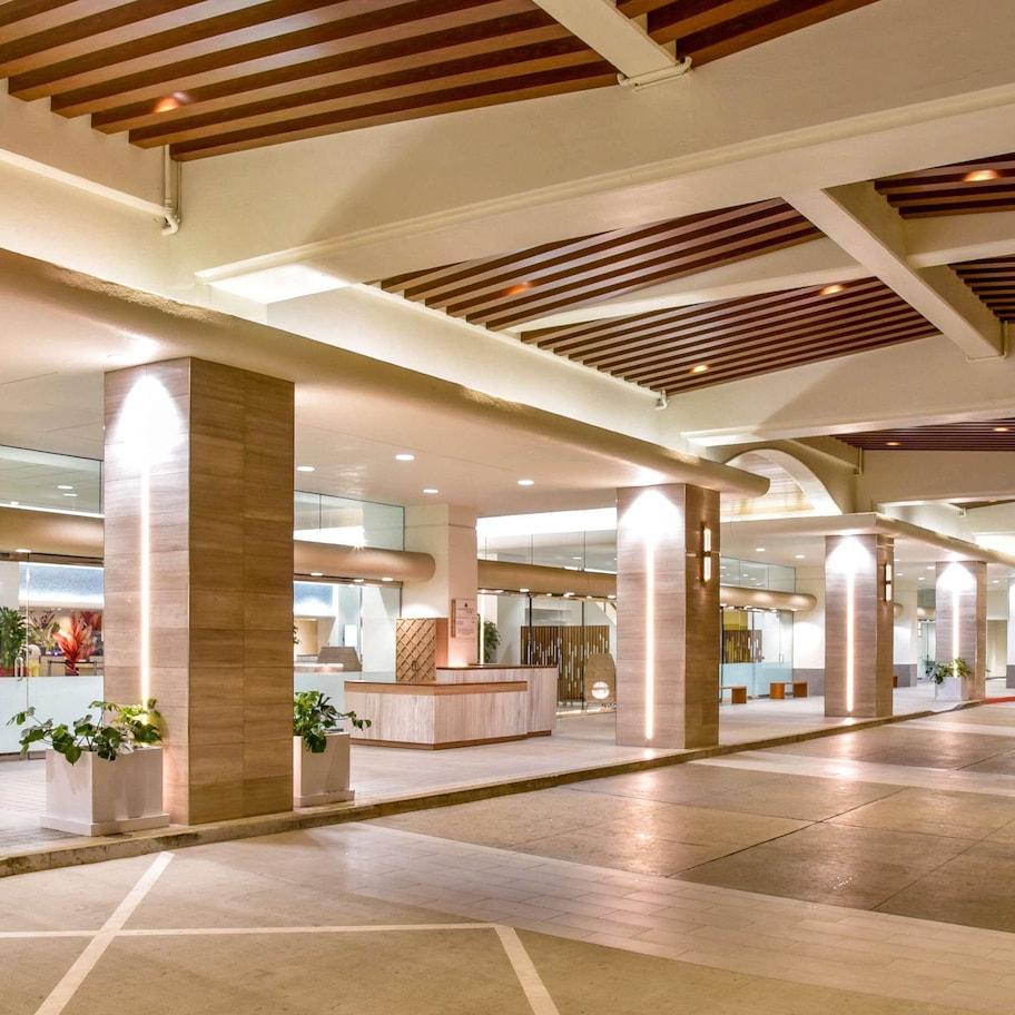 A spacious lobby with high ceilings, large pillars, and a reception desk.