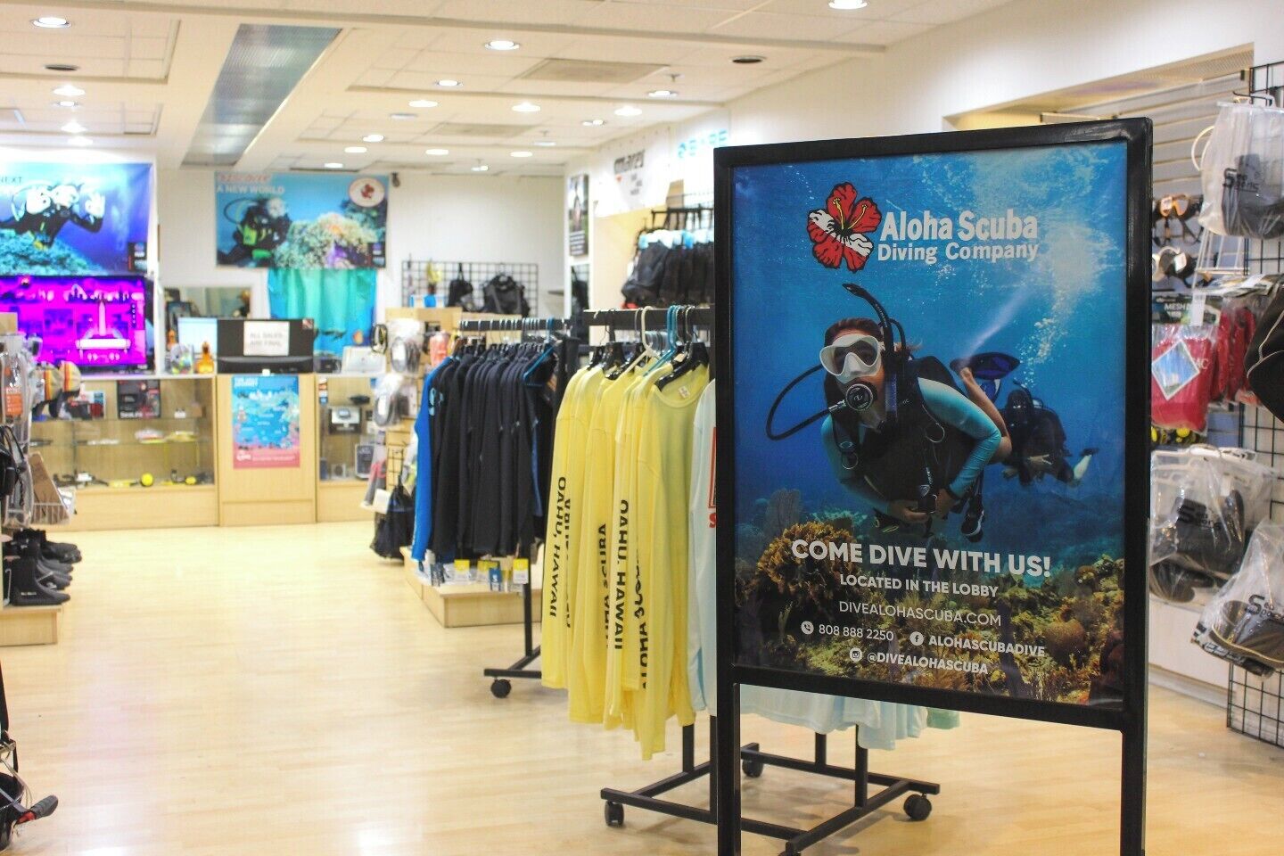A diving equipment store with racks of wetsuits and diving gear.