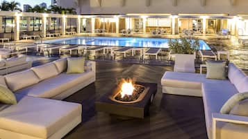 Una piscina al aire libre, sillones reclinables de piscina