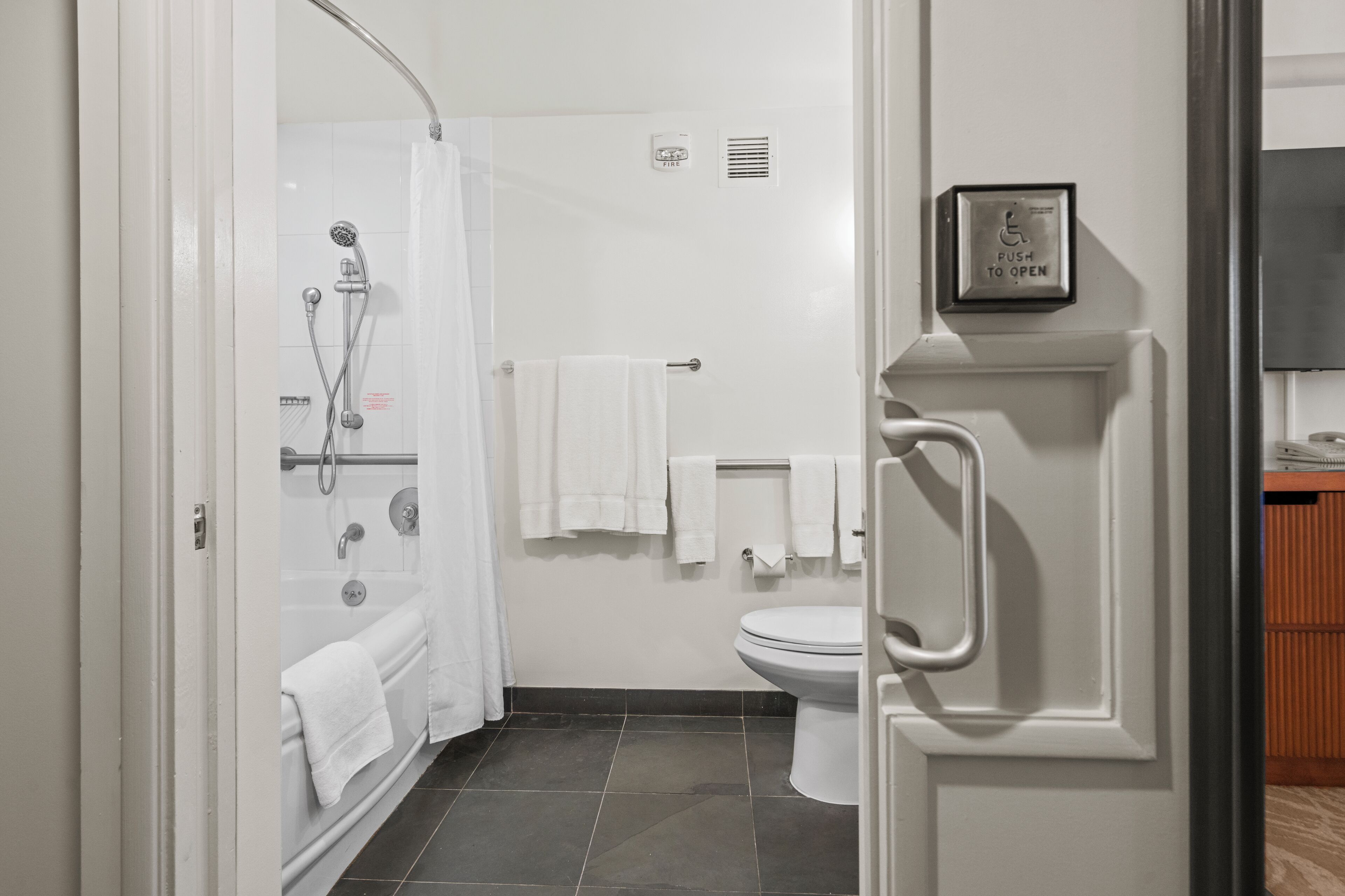 A modern bathroom with a glass shower enclosure, a toilet, and a sink.