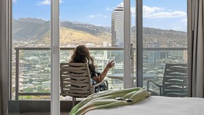 Una habitación con un ventanal que da a una vista panorámica de la ciudad y las montañas.