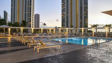 Una piscina al aire libre, sillones reclinables de piscina