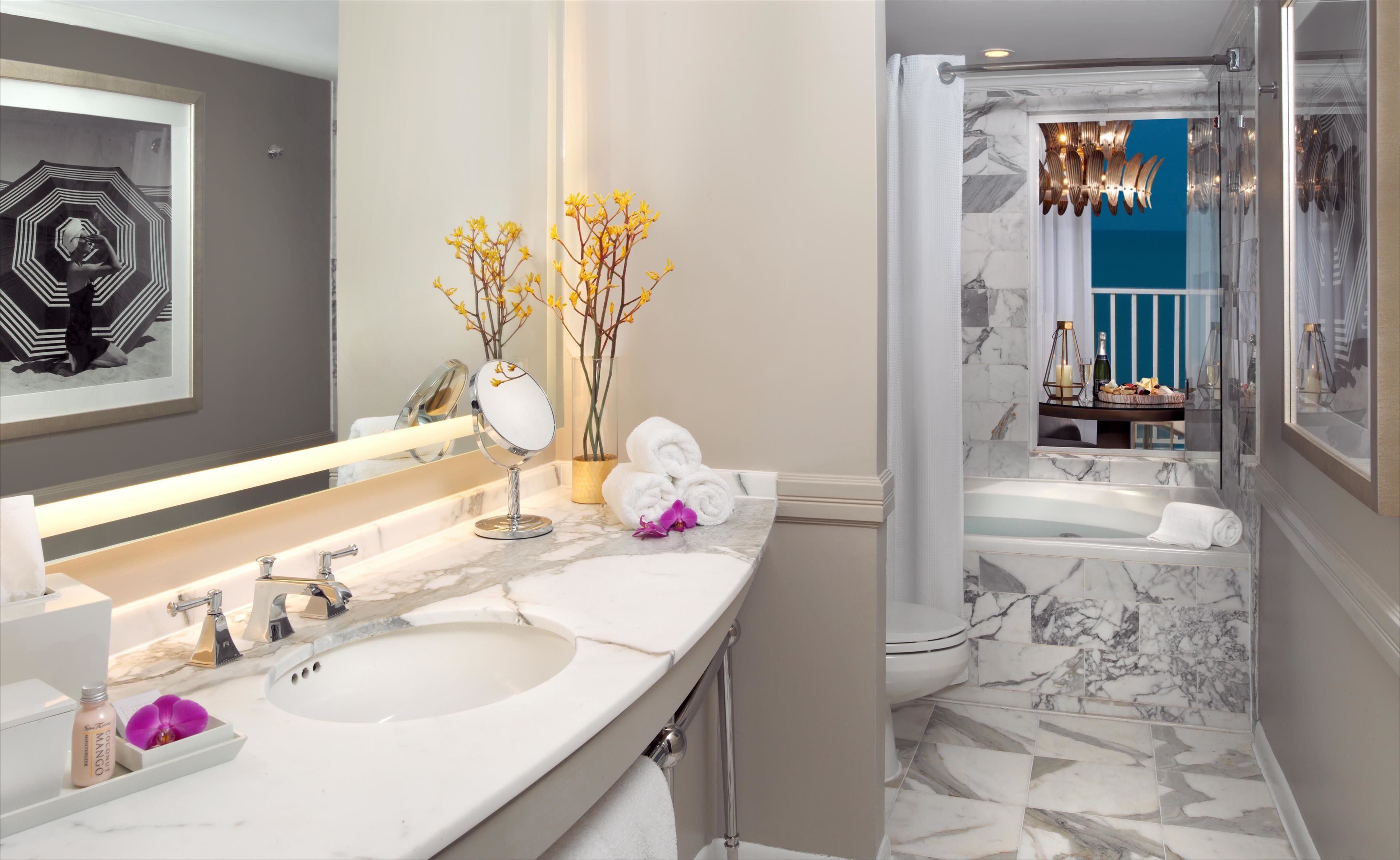 Une salle de bain moderne avec deux lavabos, un grand miroir et un espace douche.