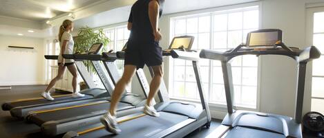 A gym with treadmills, each equipped with a laptop.