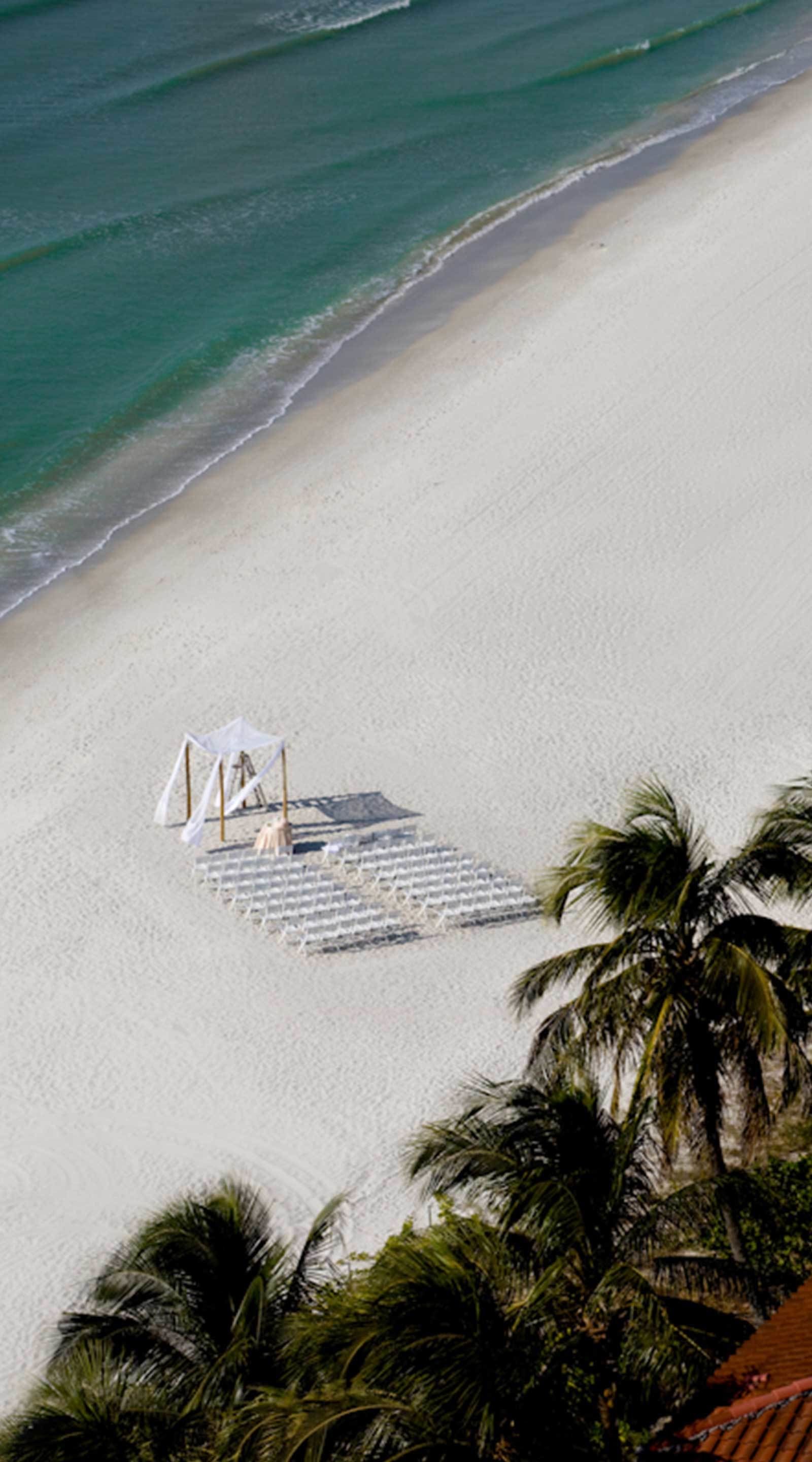 A beach with a white structure that appears to be a gazebo or pavilion.