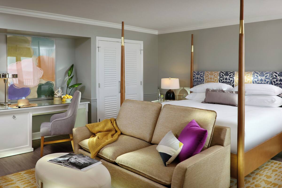 Une chambre d’hôtel comprenant un lit, un canapé, un bureau et une table de chevet.