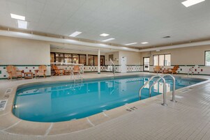 Una piscina techada, sillones reclinables de piscina