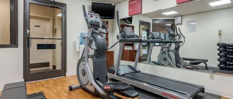 A gym with treadmills, a stationary bike, and a bench.