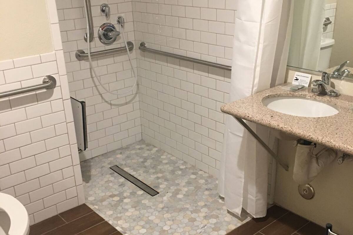 A bathroom with a shower, toilet, and sink.