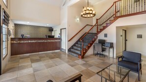 A spacious lobby with a reception desk, a staircase, and a seating area. - Best Western Town & Country Lodge (Tulare)
