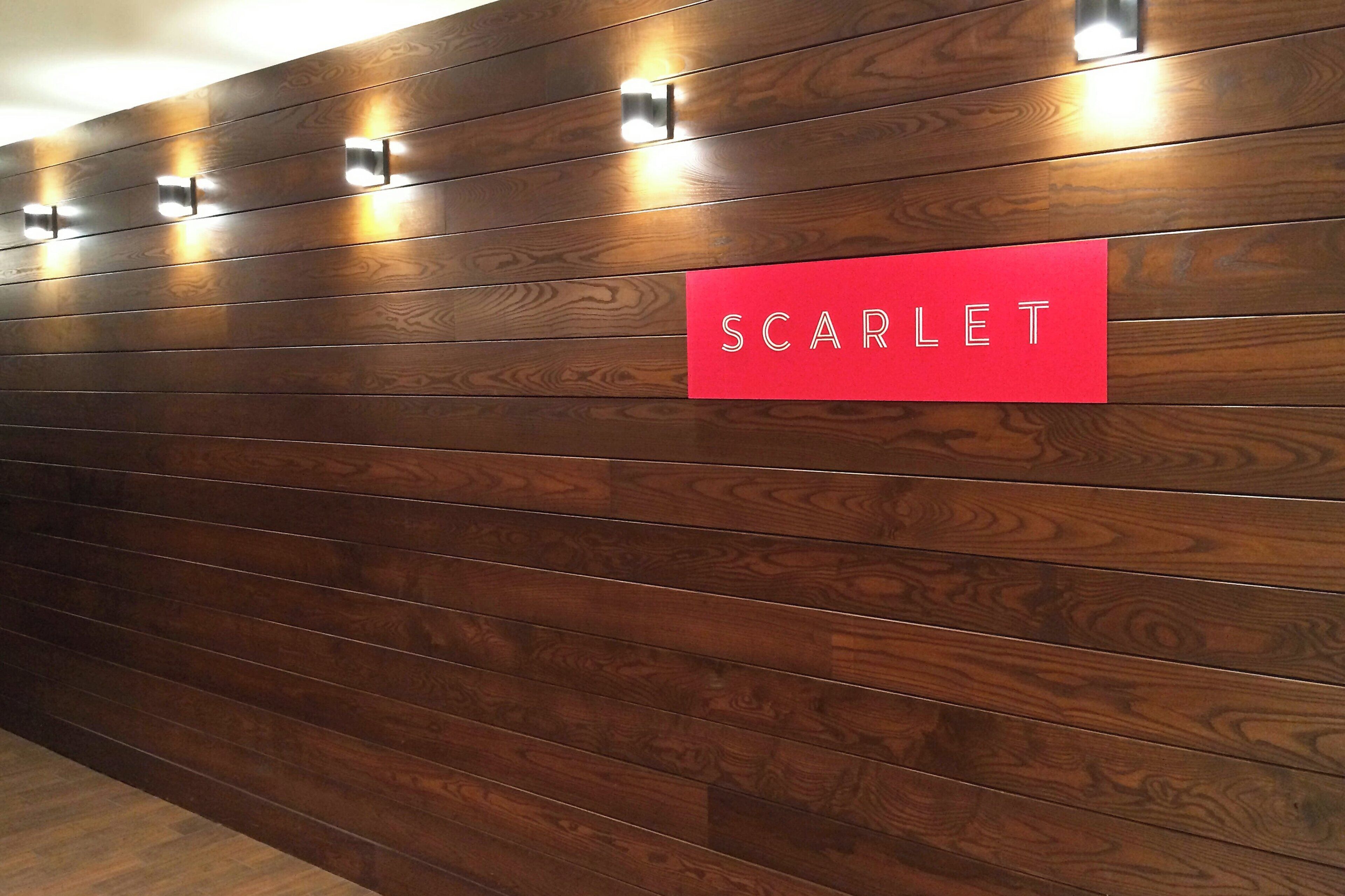 A wall with a red sign labeled "SCARLET" and three wall-mounted lights.