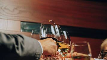 A group of people toasting with wine glasses at a bar.