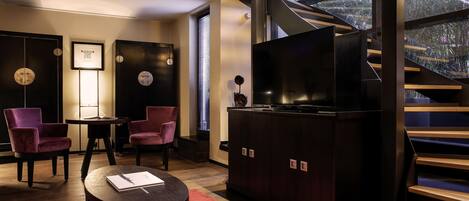 Un interior moderno con una escalera, un televisor y zona de estar.