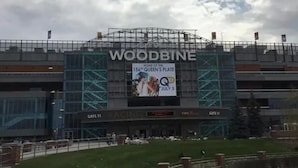 A stadium with "WOODBINE" written on the facade, "GATE 11" and "RACING" signs, and a banner advertising "HOME OF THE 156th QUEEN'S PLATE JULY 5". - Comfort Hotel Airport North (Toronto)