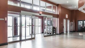 A spacious lobby with a high ceiling, glass doors leading to the entrance, and a clear view of the outside. - Comfort Hotel Airport North (Toronto)