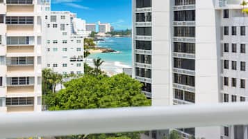 A high-rise hotel with multiple floors, large windows, and a view of the ocean.