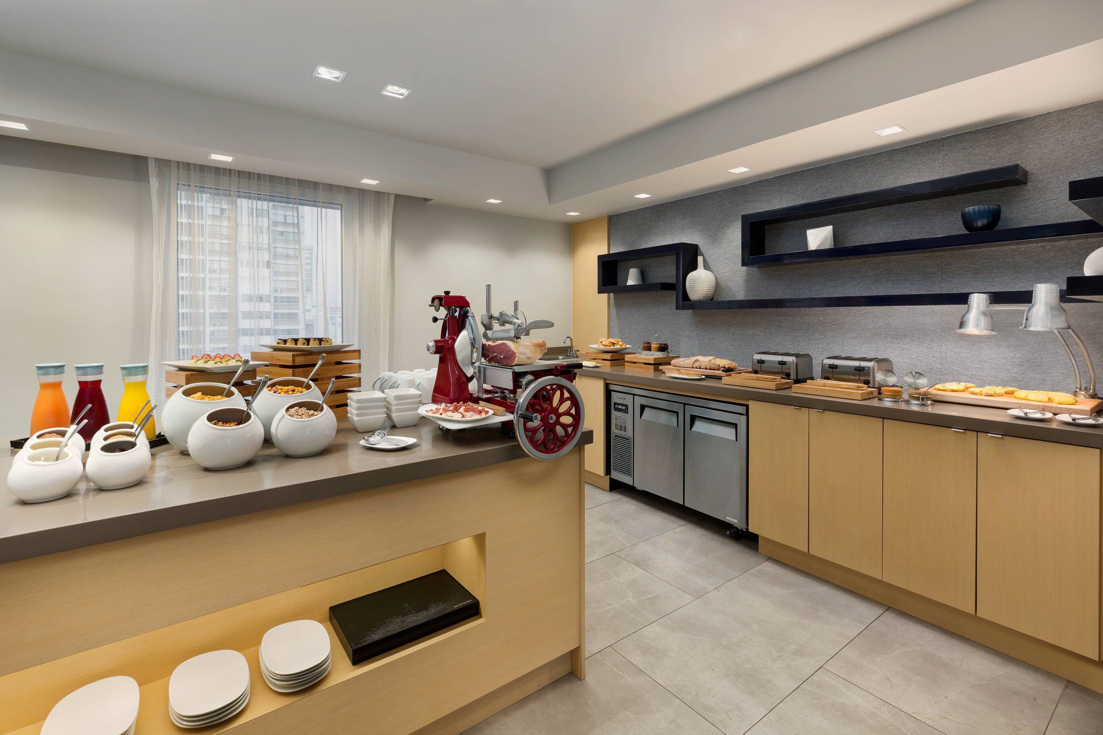 A modern kitchen with a buffet setup, including various food items and utensils.
