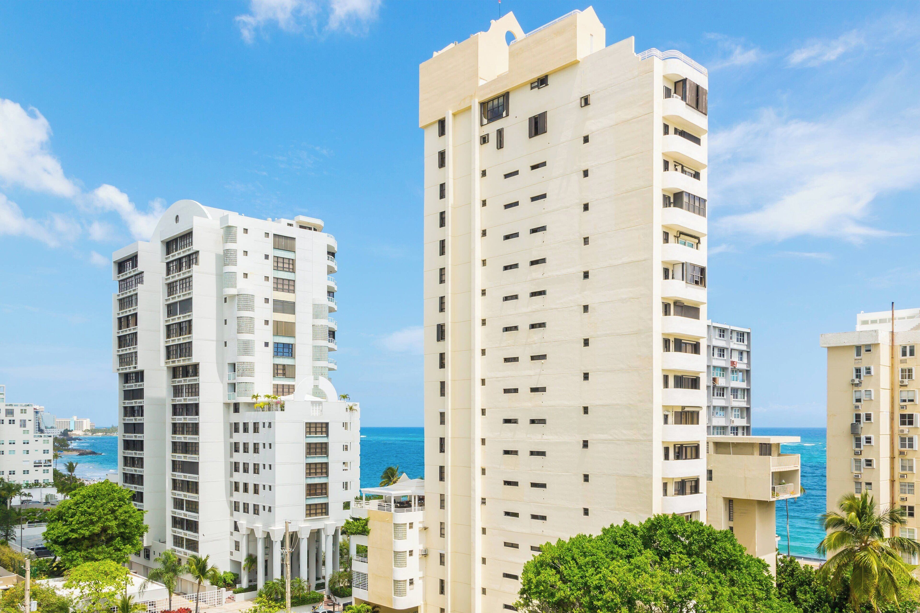 Un hotel moderno de gran altura con varias plantas, balcones y vista al océano.