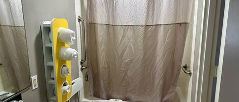 Un baño con bañera, lavabo y toallero con varias toallas.