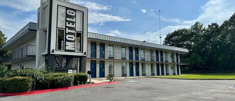 A motel with a prominent 'Motel 6' sign, multiple rooms, and a parking lot.