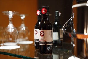 En flaske Santa Digna vin på en glaskarm med et sløret baggrund af vinglas.