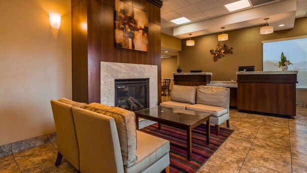 A lobby with a fireplace, seating area, and a reception desk.