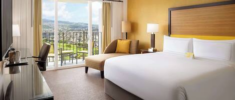 Habitación de hotel con una cama grande, un escritorio, una silla y vistas a un paisaje urbano a través de amplias ventanas.