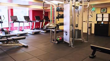 A gym with treadmills, weight machines, and a squat rack.
