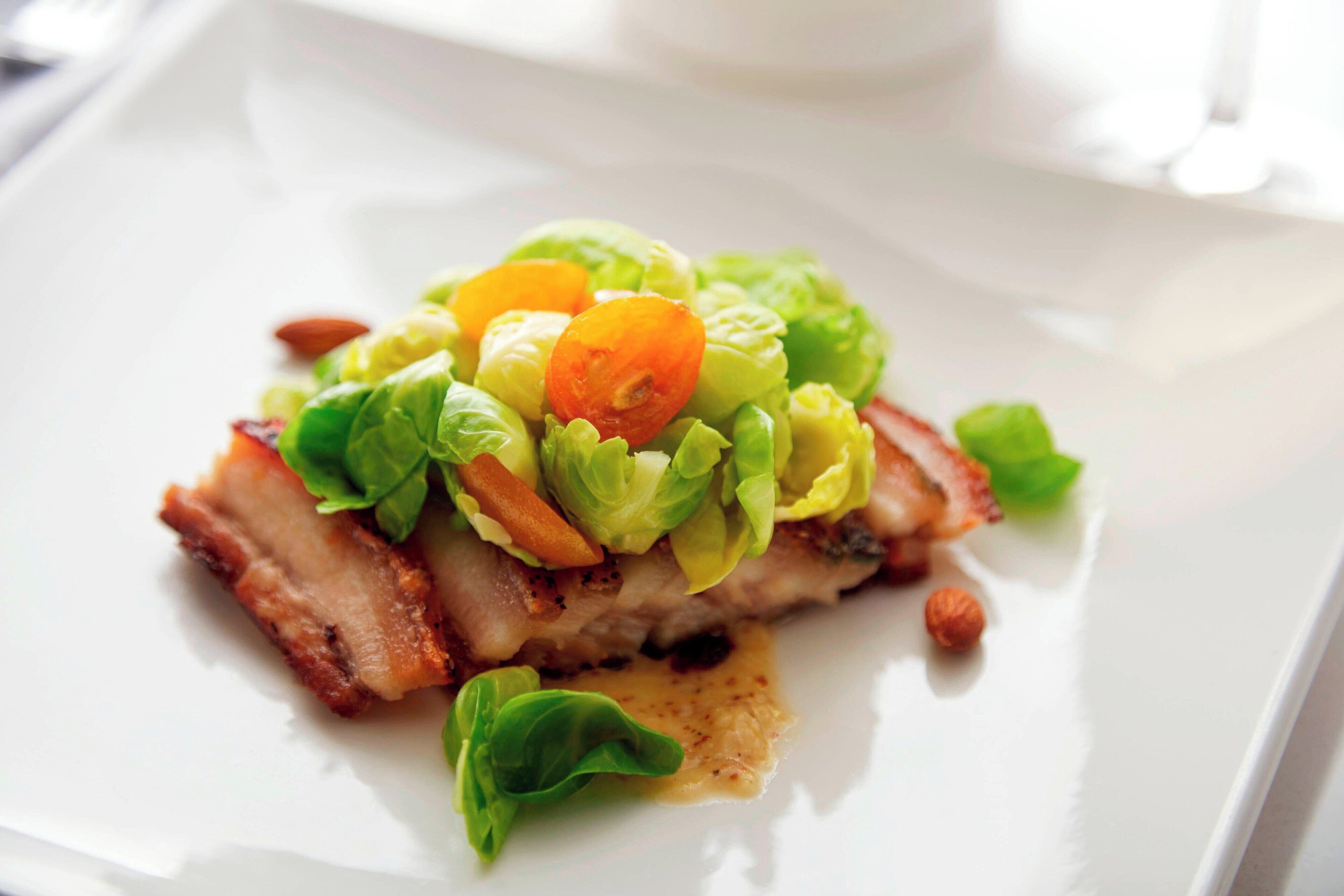 Un plato con carne, lechuga y tomates cherry.