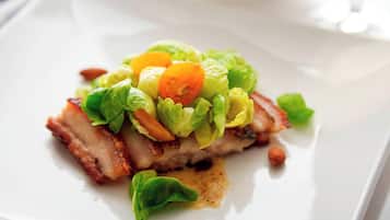 Un plato con carne, lechuga y tomates cherry.