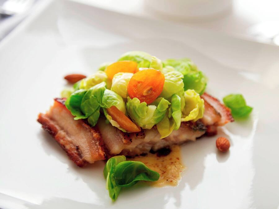 Un plato con carne, lechuga y tomates cherry.
