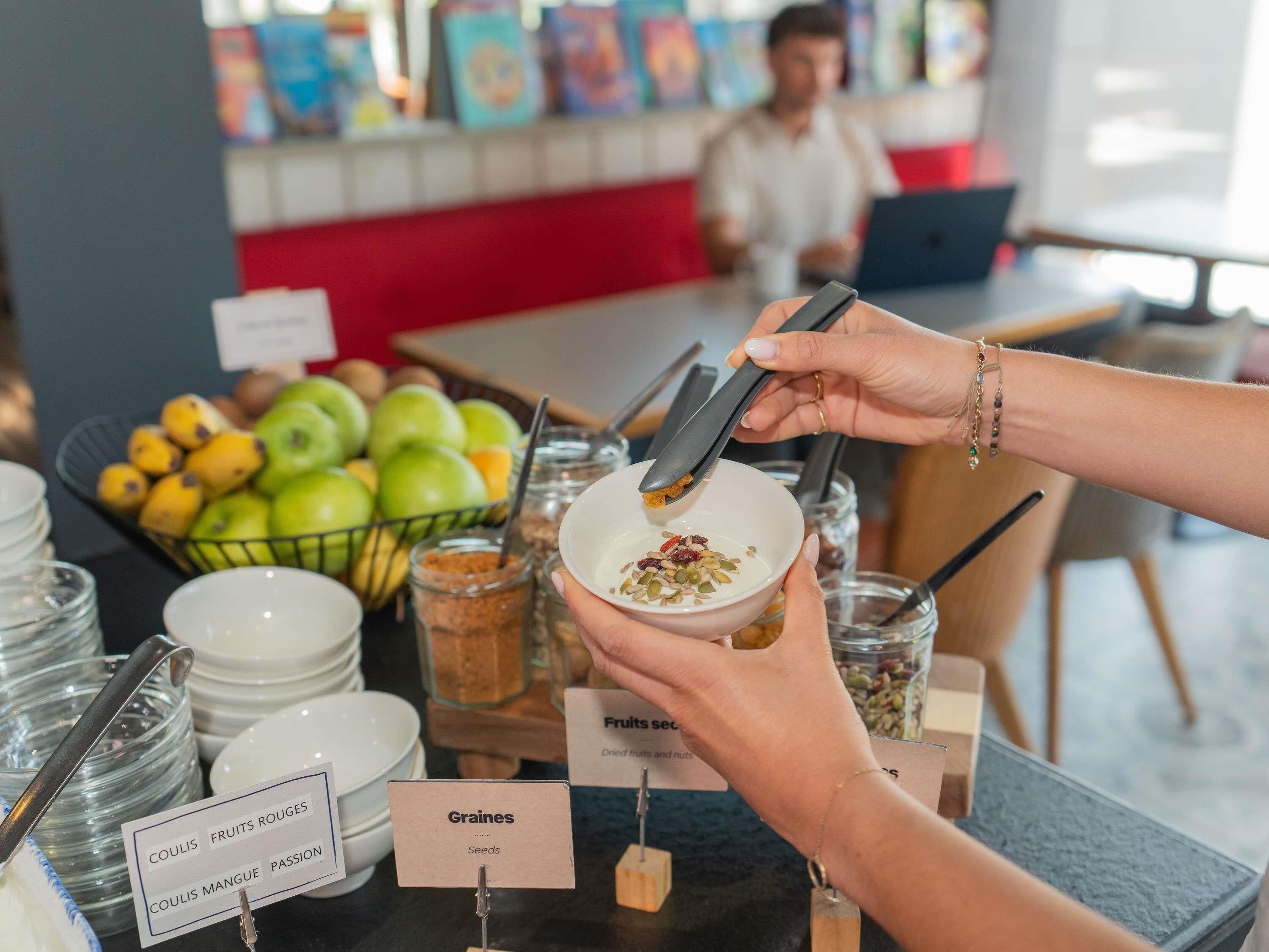 Disposição de buffet com áreas de alimentos identificadas, incluindo frutas e sementes.