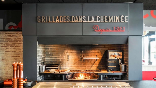 Un restaurante con pared de ladrillo y zona de parrilla.