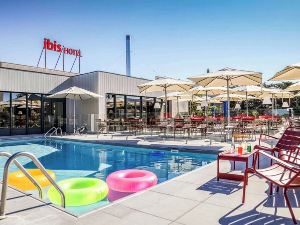 Relax by the pool surrounded by comfortable seating and umbrellas.