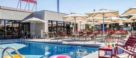 Una piscina al aire libre, sillones reclinables de piscina