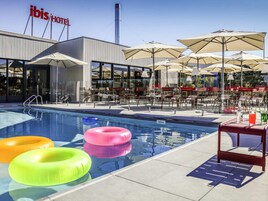 Una piscina al aire libre, sillones reclinables de piscina