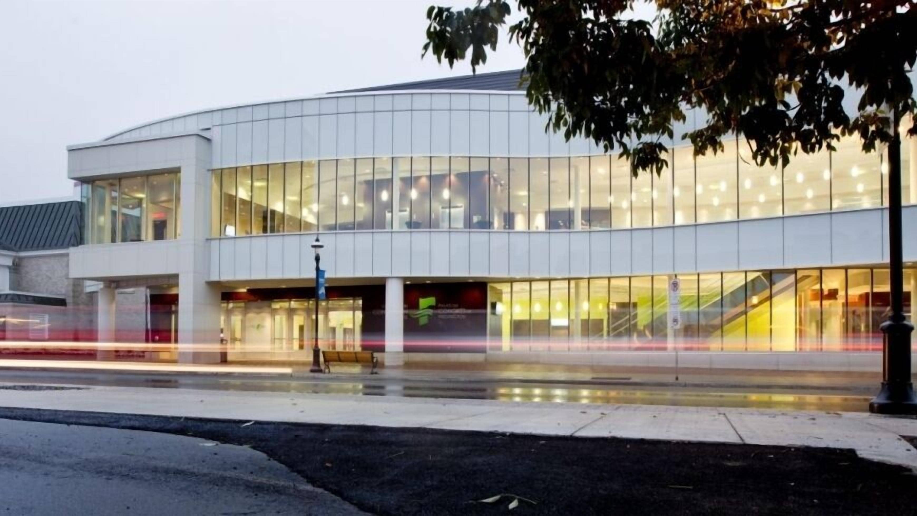Um edifício moderno com grandes janelas de vidro e fachada curva.