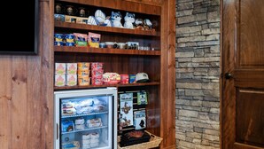 Una estantería de madera con diferentes alimentos y un refrigerador pequeño.