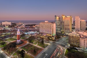 A cityscape with a prominent clock tower, modern high-rise buildings, and a well-lit urban area.
