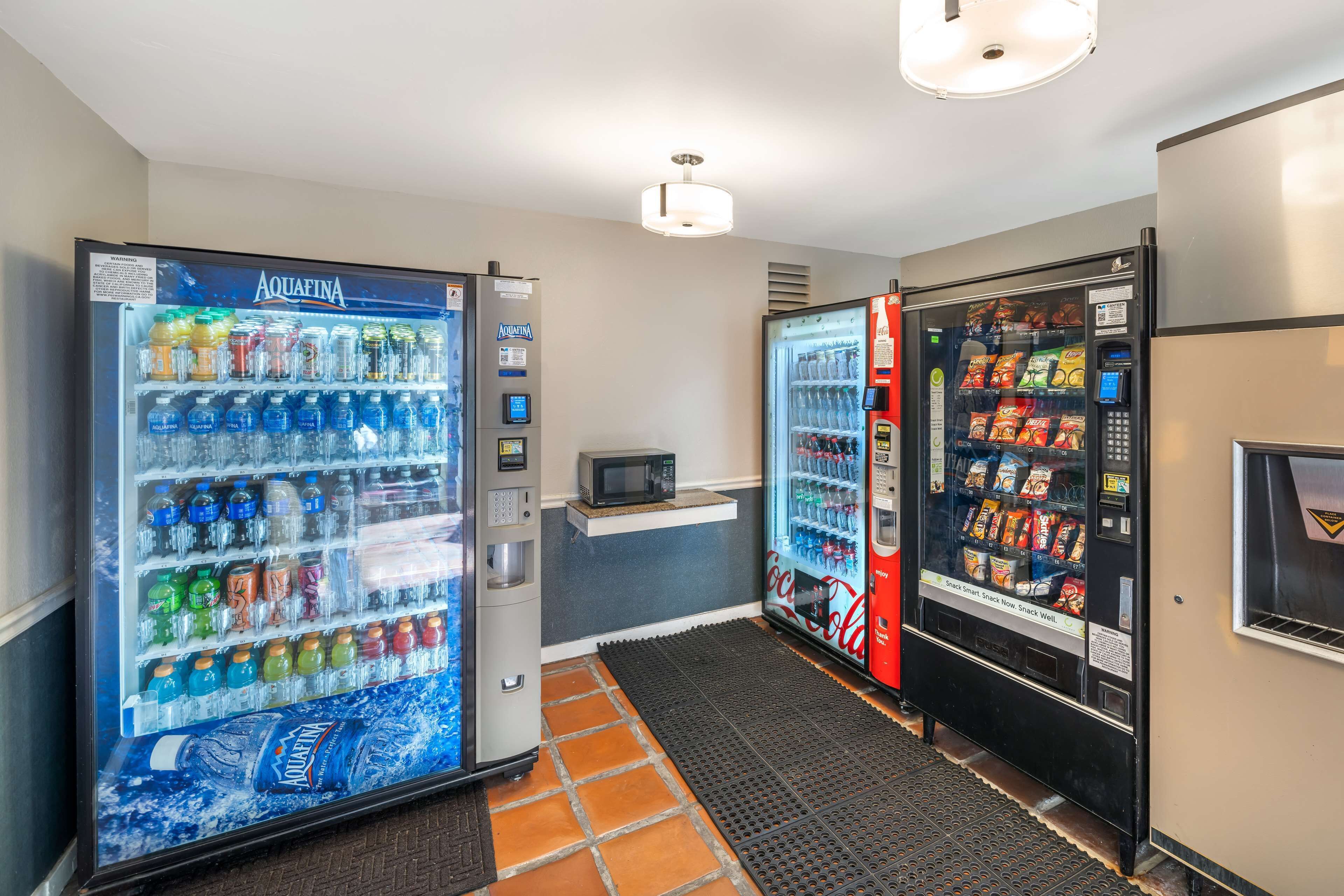 Un corridoio con distributori automatici di acqua Aquafina, Coca-Cola e snack.