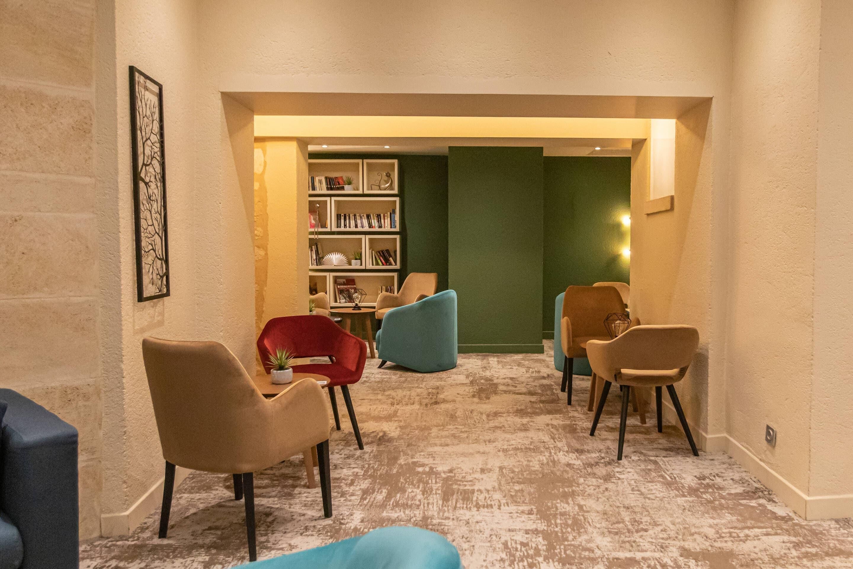 Un intérieur moderne avec un sol recouvert de moquette, une bibliothèque et plusieurs chaises.